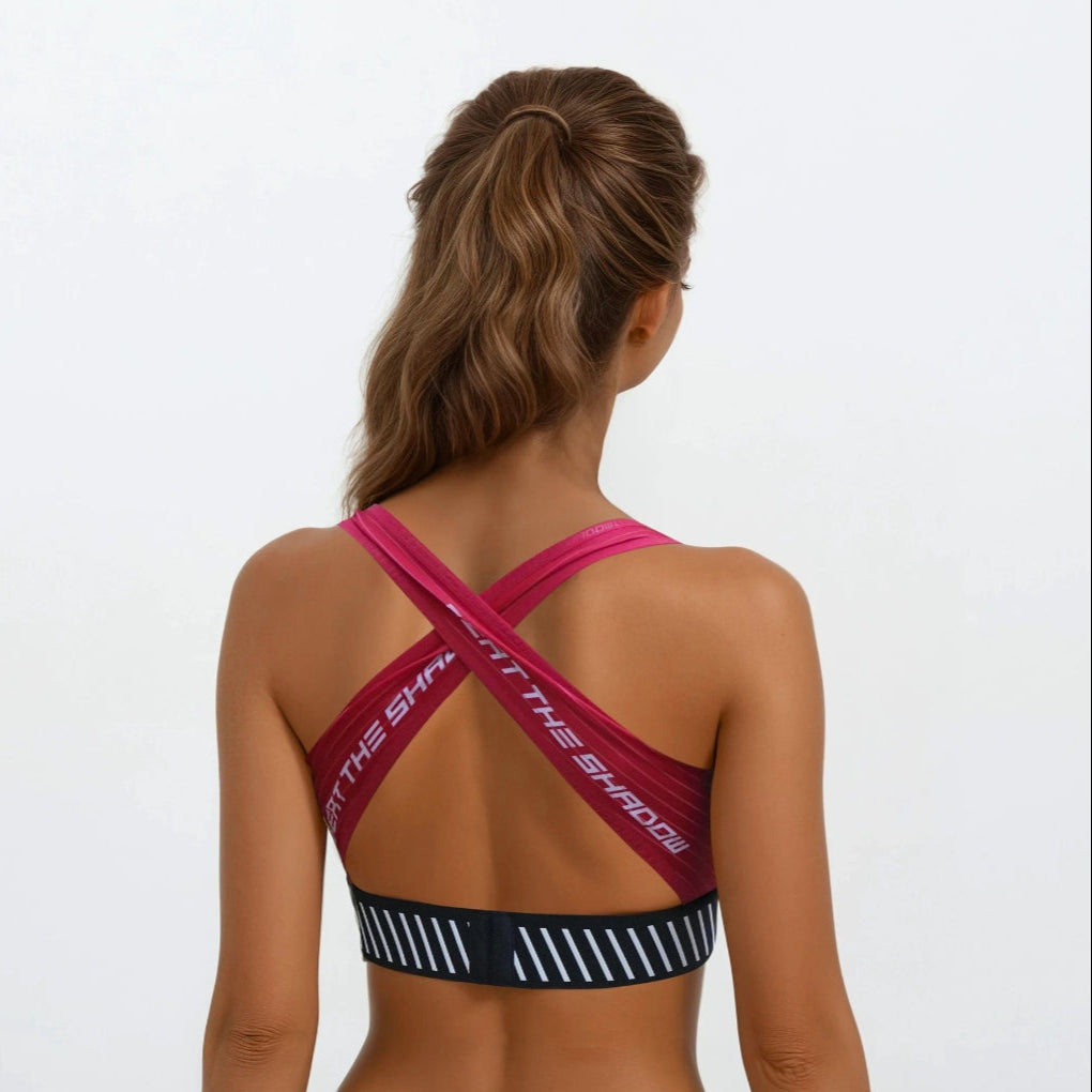 Woman wearing a sports bra with criss-cross straps on a white background