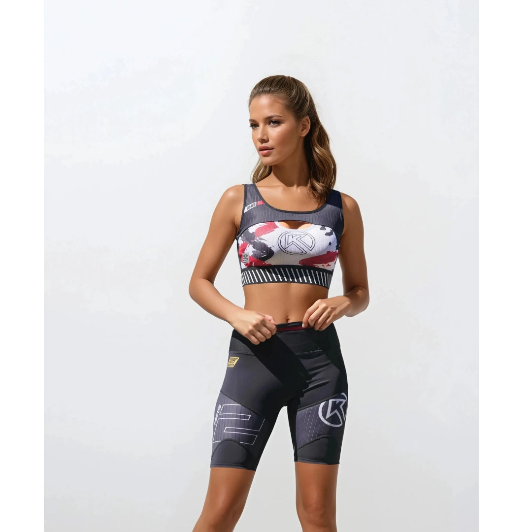 Woman wearing a sports bra and shorts with a white background